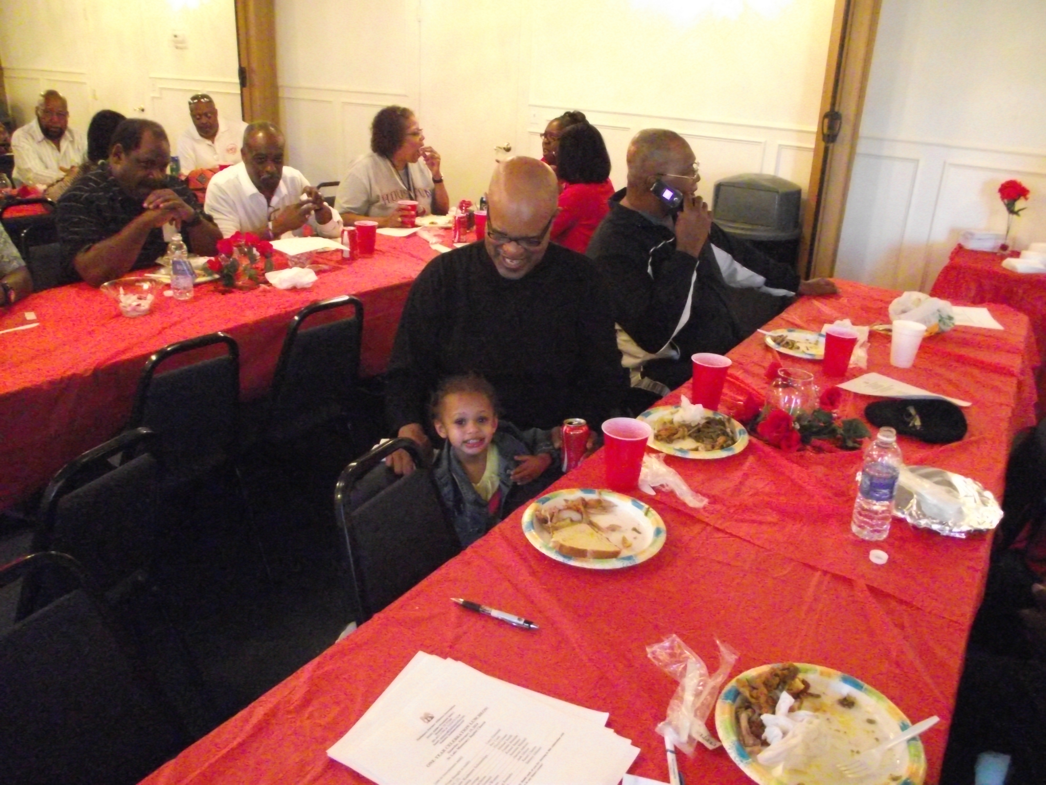 A group of people sitting at tables with plates.