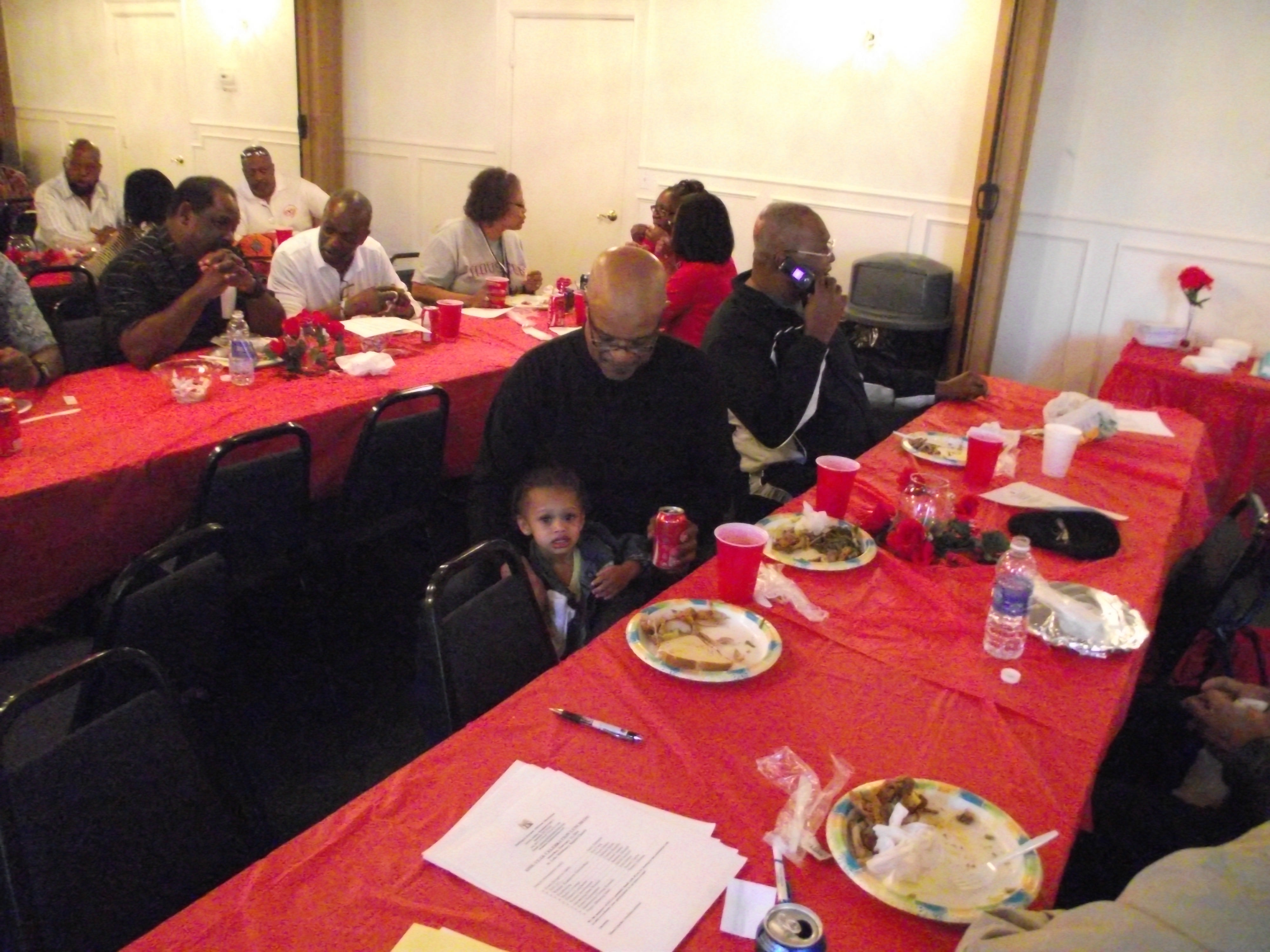 A group of people sitting at tables eating food.