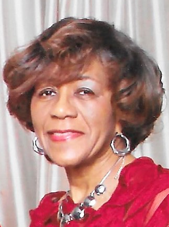 A woman with short hair wearing a red dress.