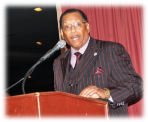 Man speaking at podium with microphone.
