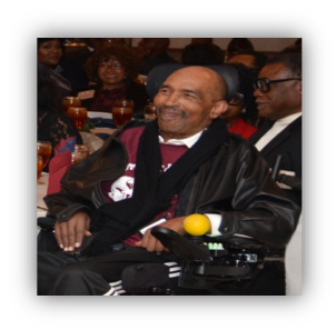 Man smiling in wheelchair at event.