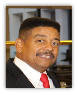 Man in suit with red tie smiling.