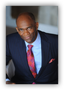 Man in suit with patterned tie smiling.