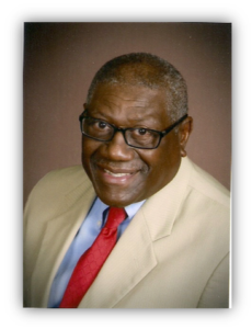 Man smiling in suit and glasses.