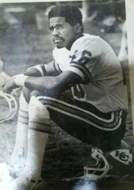 Football player sitting on the sideline.