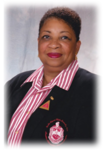 Smiling woman in striped shirt and blazer.