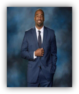Man in blue suit, smiling confidently.