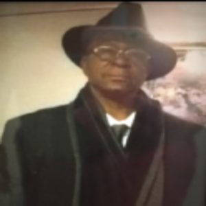 Man wearing hat and coat indoors.