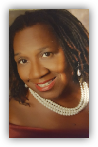 Smiling woman with pearl necklace and earrings.