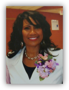Smiling woman with floral corsage.