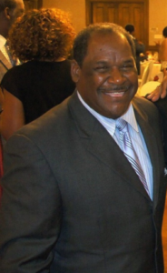 Man smiling in formal event setting.