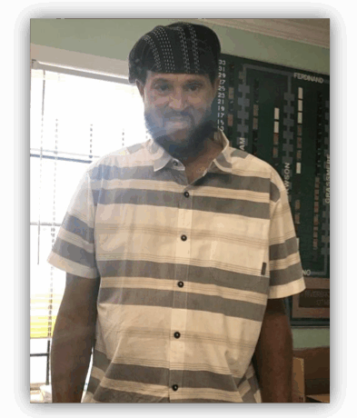 Man in striped shirt and hat indoors.