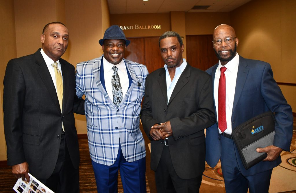 Four men in suits and ties posing for a picture.