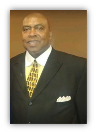 Man in suit with patterned tie smiling.
