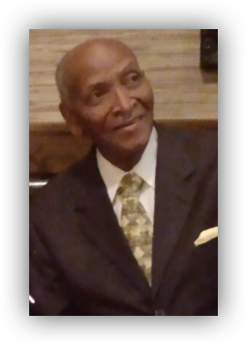 Elderly man smiling in a suit.