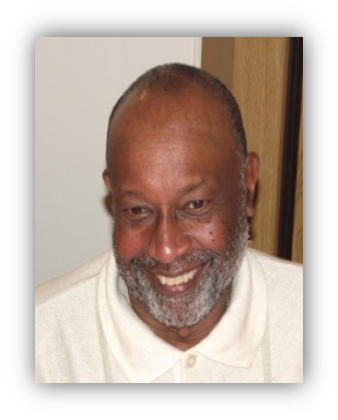 Smiling man with a beard indoors.