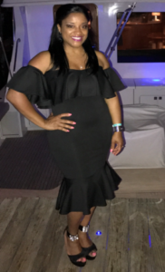 Woman in black dress standing on deck.