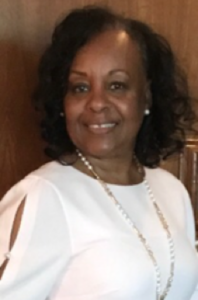 Woman smiling in white blouse.