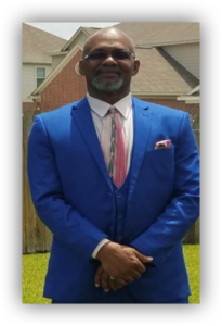 Man in blue suit with pink tie.