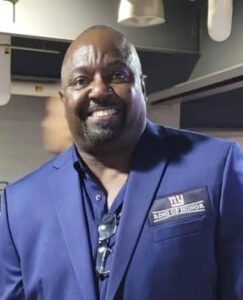 Smiling man in blue suit indoors.